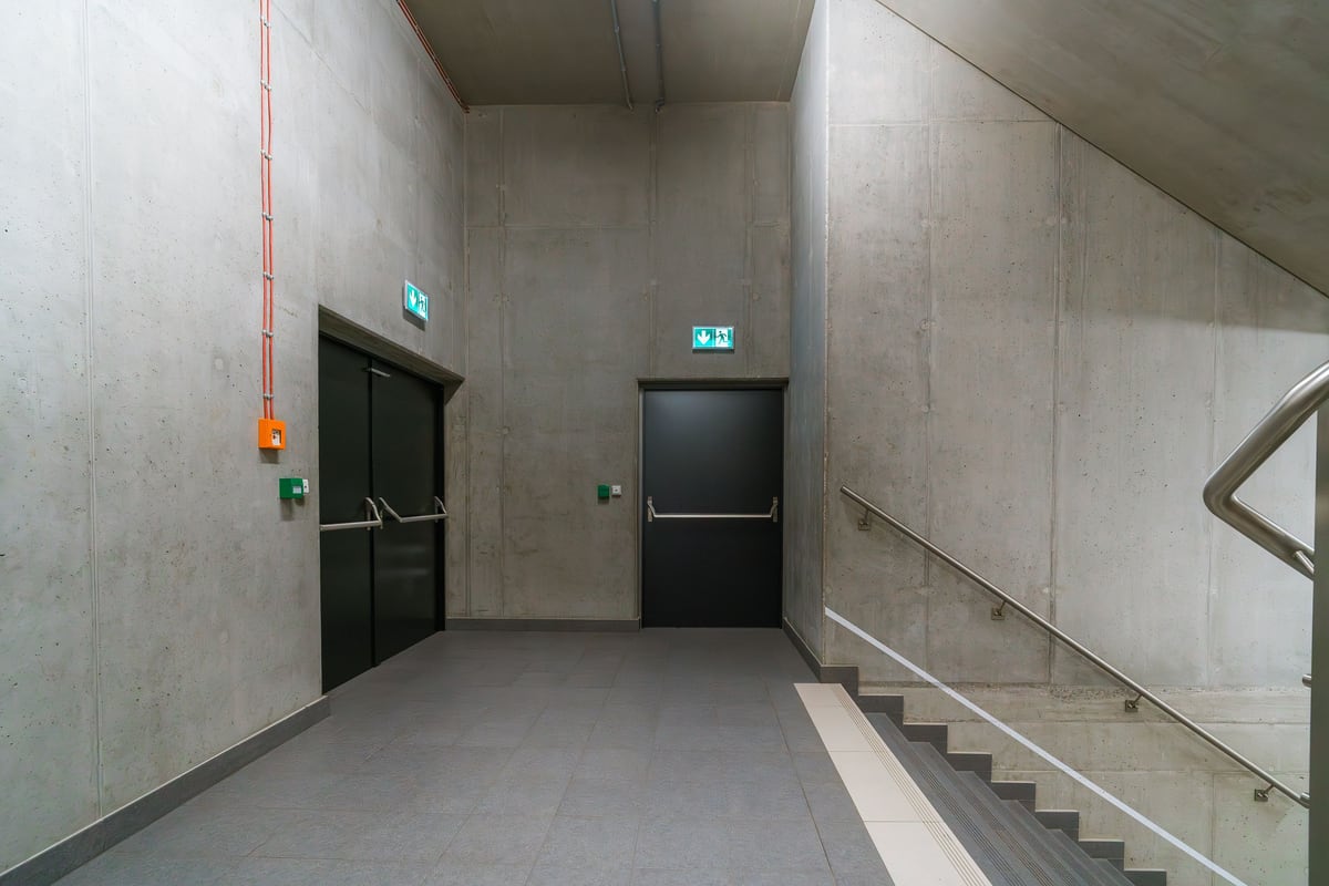 Vom Trockenbauer brandschutztechnisch ertüchtigtes Treppenhaus mit Brandschutztüren und Fluchtwegbeschilderung